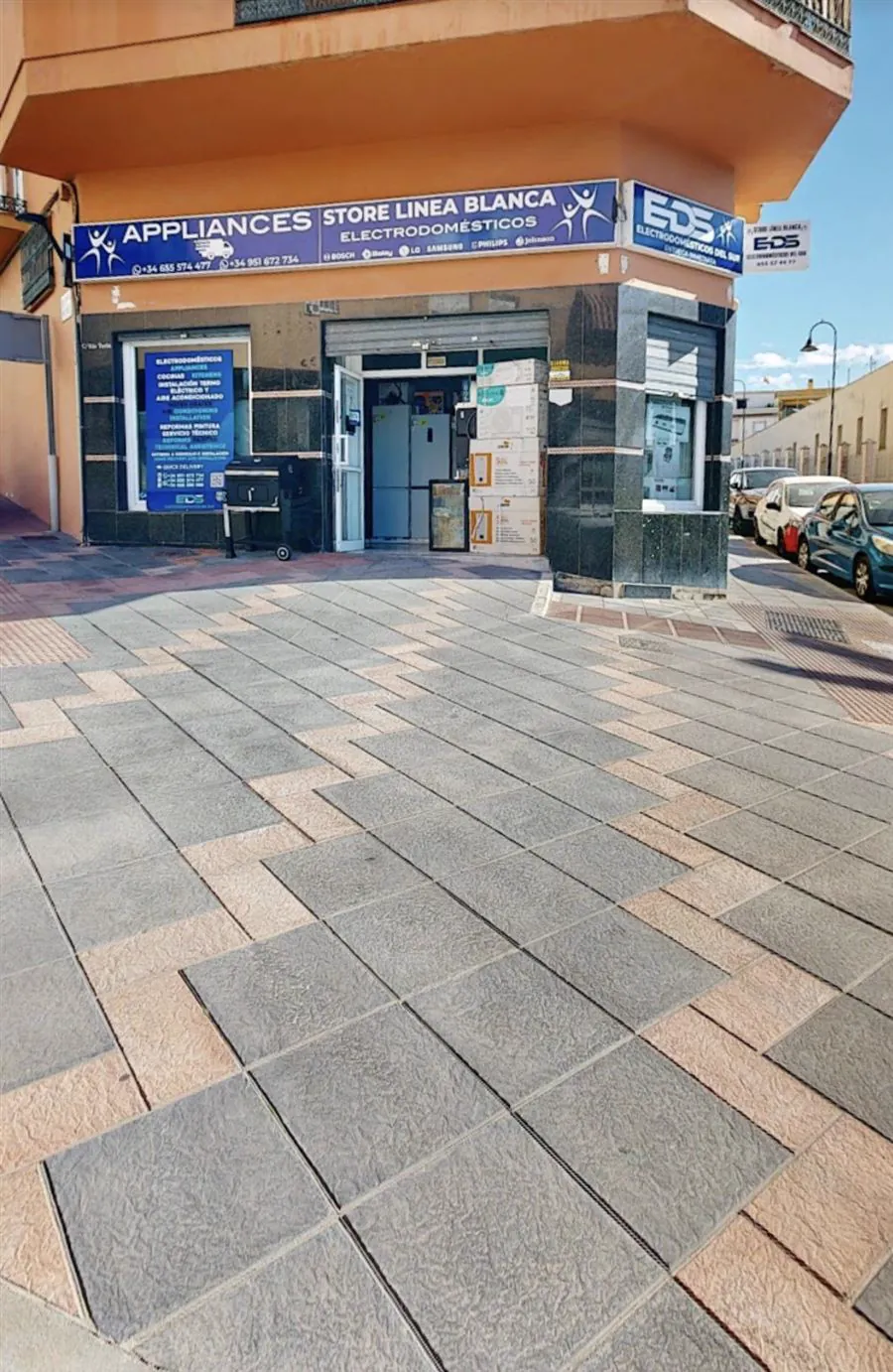 Fachada de la tienda en una esquina, con el cartel azul de EDS y frigoríficos visibles en la puerta